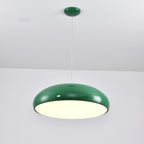 Green Clérachic dome pendant lit and seen from slightly below, with a spotlight in the white ceiling above.