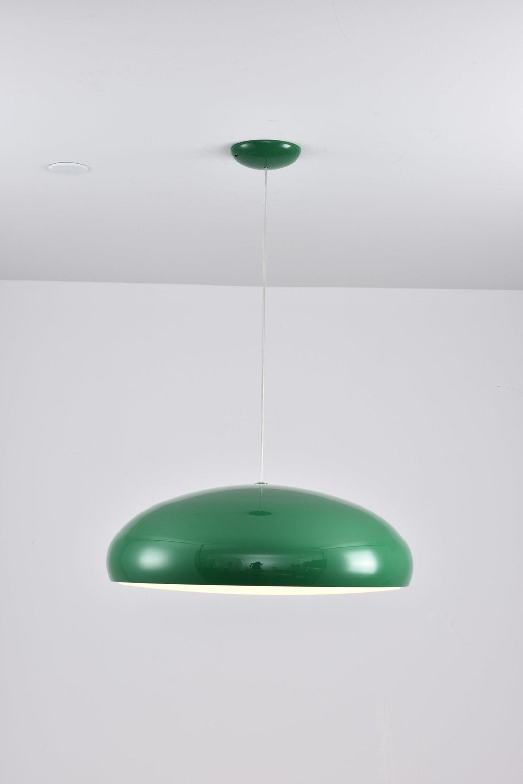 Smaller green Clérachic dome pendant on a pale backdrop, hung from a green canopy with a thin cable.