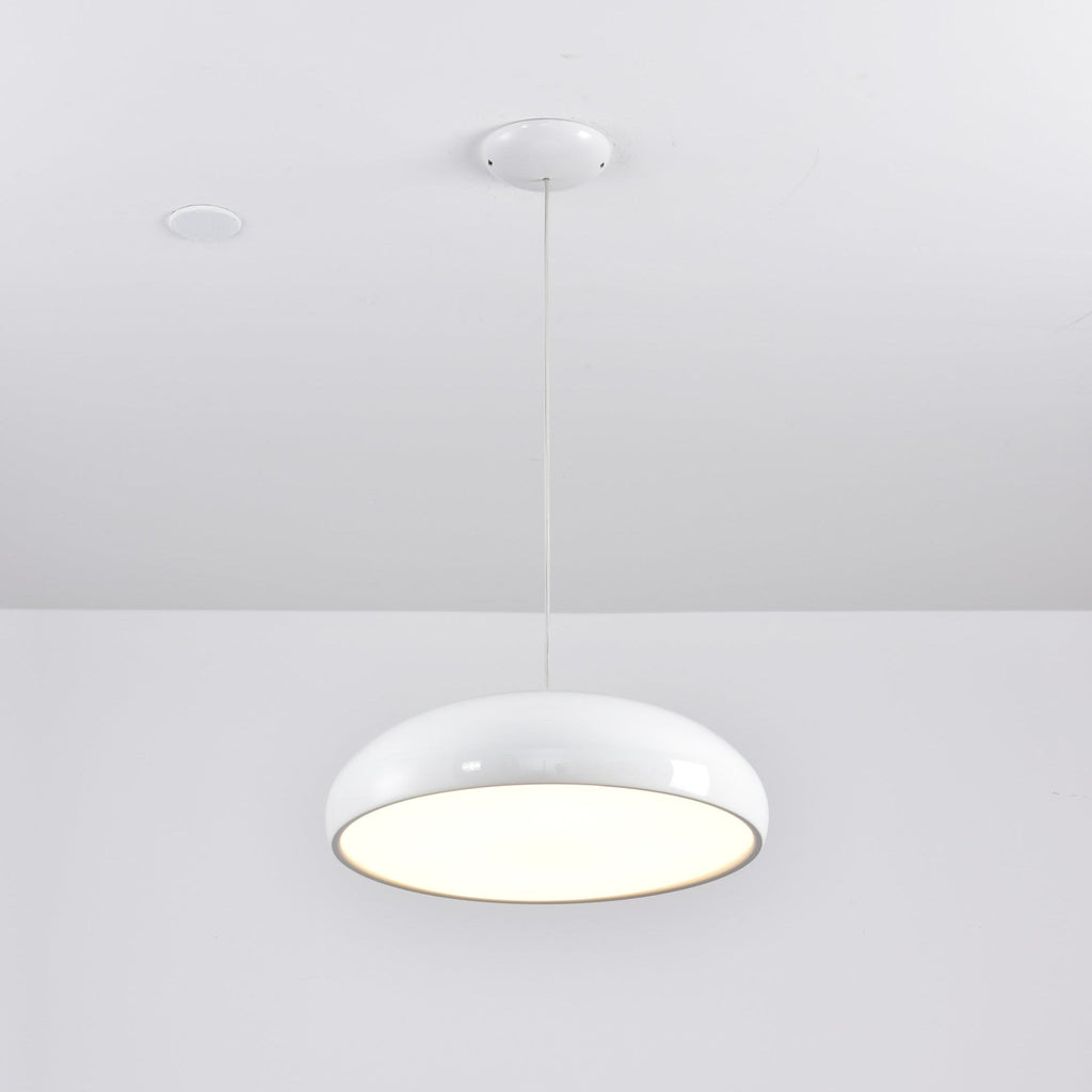 White Clérachic dome pendant seen from below with its diffuser glowing, hung from a white ceiling canopy.