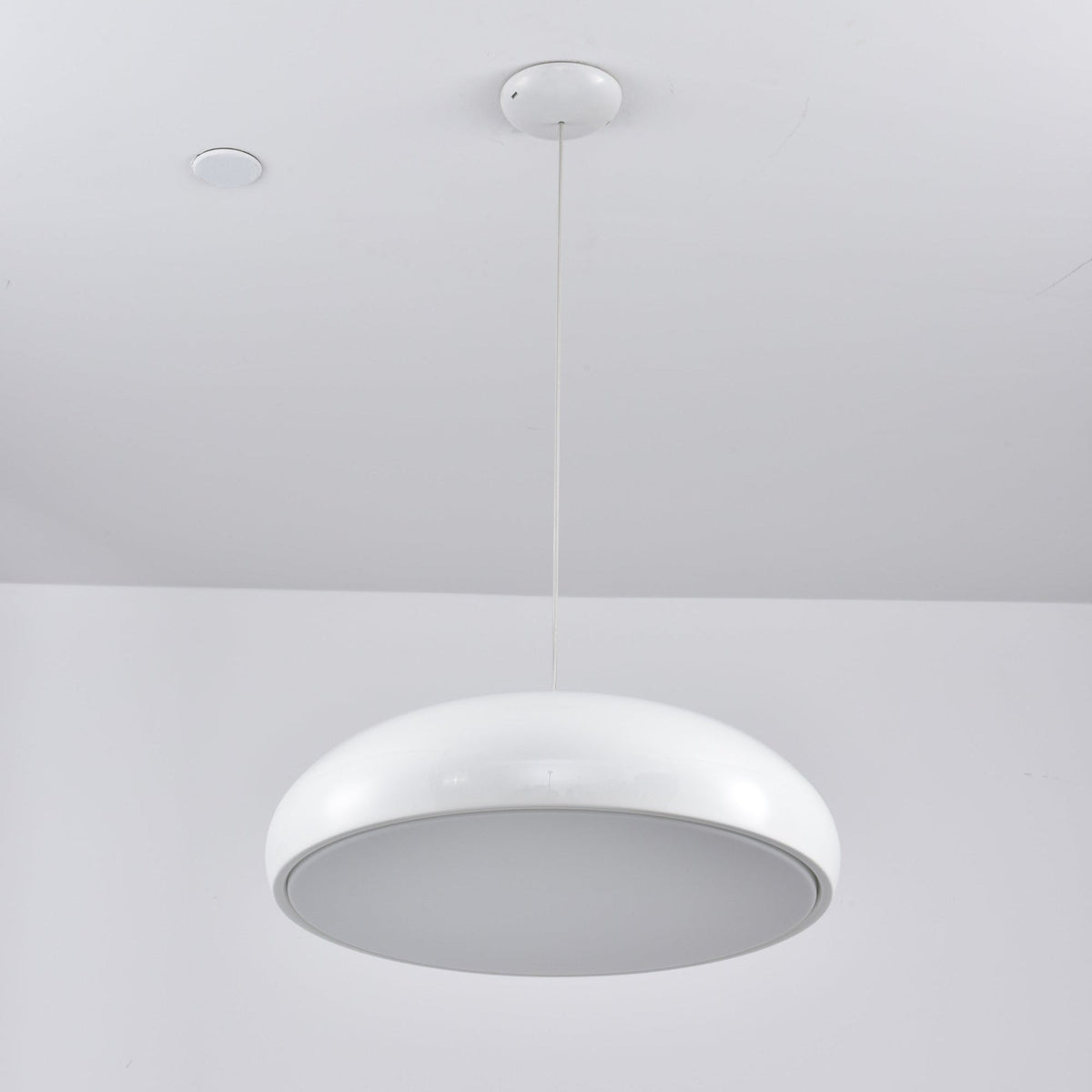 White Clérachic dome pendant viewed from beneath, its grey diffuser disc unlit inside a white rim.