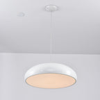 White Clérachic dome pendant lit from below, the diffuser glowing a warm peach inside its glossy rim.