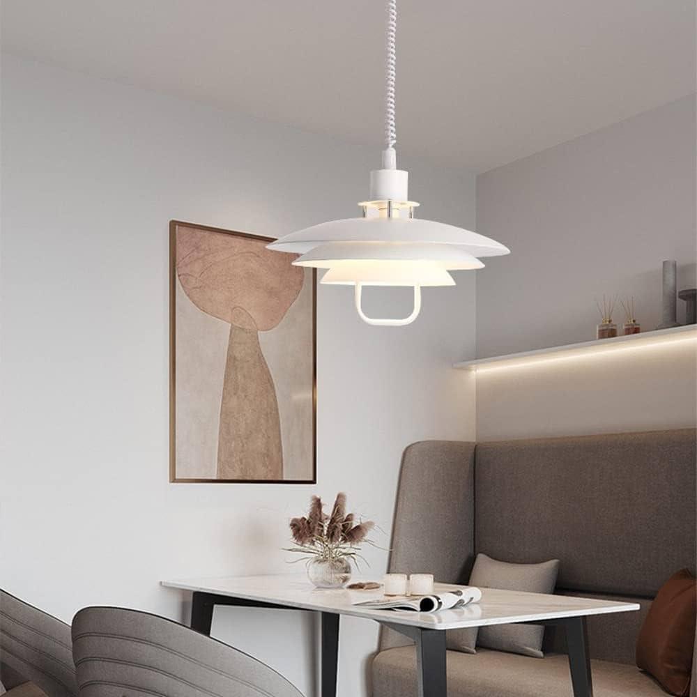In a dining corner with a banquette and an abstract print, a white Clérachic pendant hangs low over a small table.