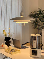 Another angle of a white Clérachic pendant over a laptop desk with a tray and a vase of dried flowers.