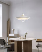 A white Clérachic pendant hangs over a round marble-top table, in a calm room with a rolled rug against the wall.