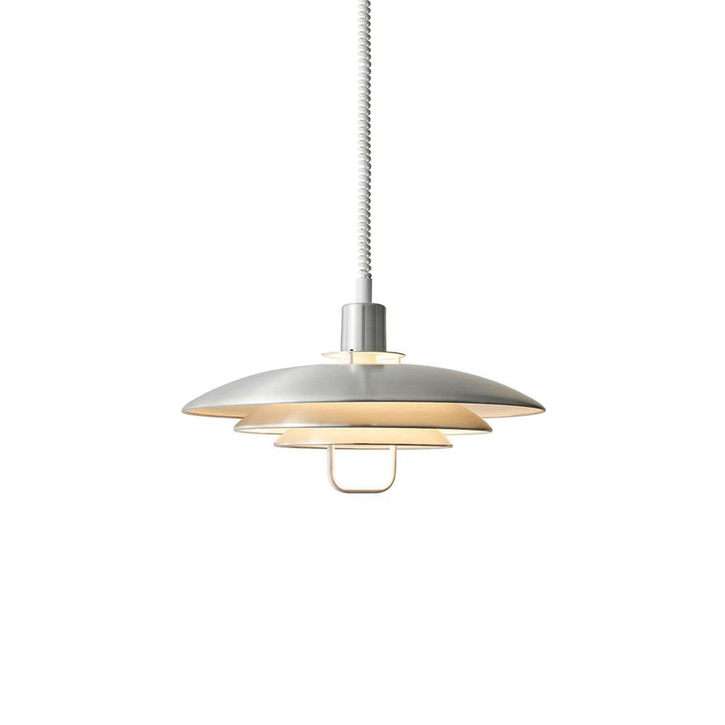 Silver Clérachic pendant on a white backdrop, lit softly inside, with a metal collar and a pale loop handle.