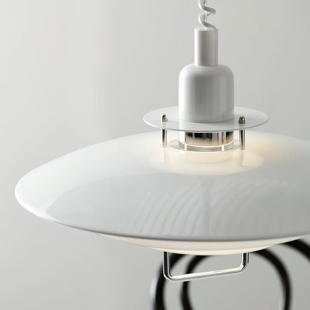 Close view of the glossy white top shade and the clear collar around the bulb on this Clérachic pendant.