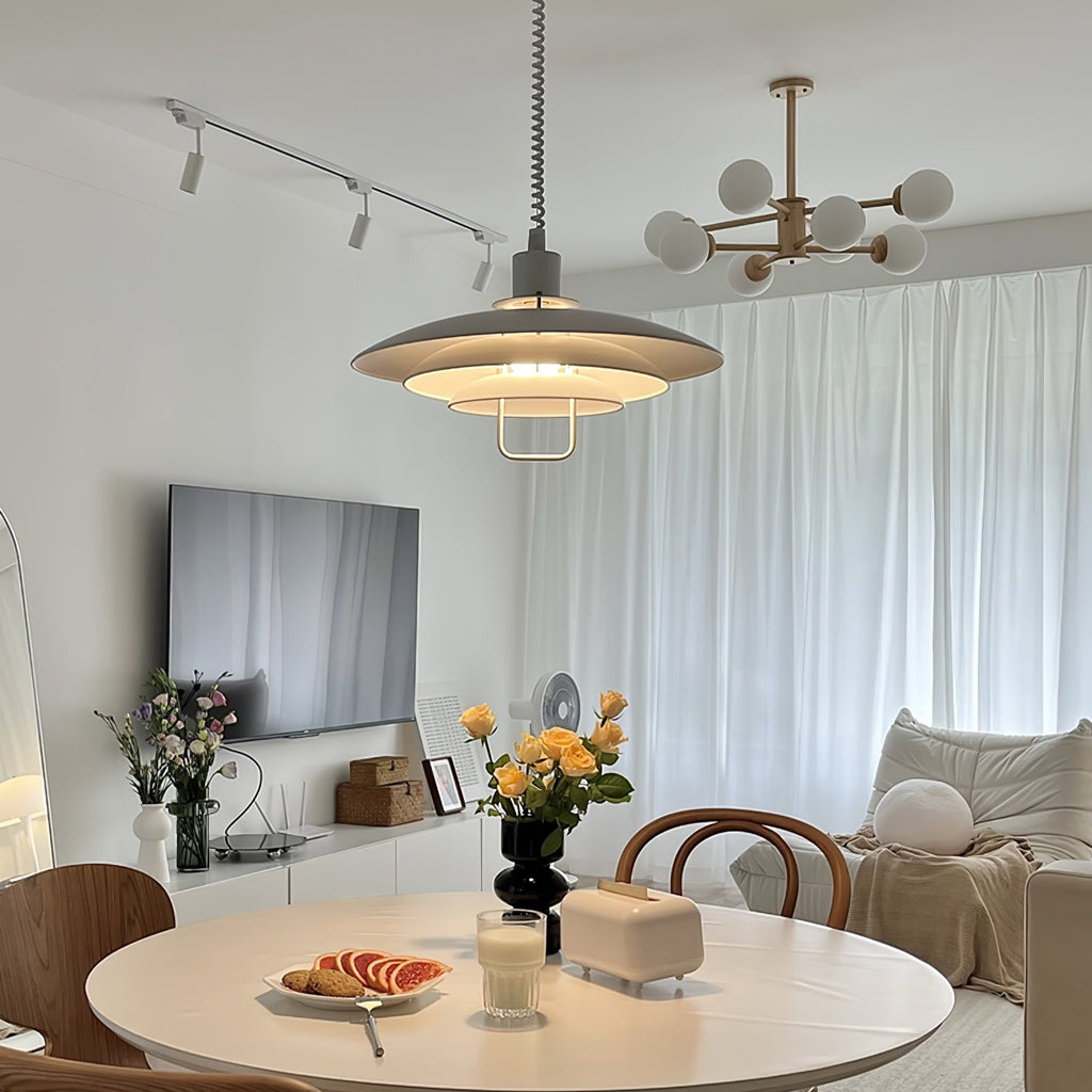 A nearer view of the same room, with a grey-and-white Clérachic pendant glowing over a table of citrus and flowers.