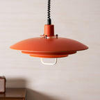 Looking up at the wide orange top shade of this Clérachic pendant, with the white handle below the lowest tier.