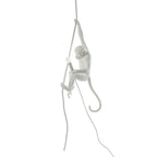 Small white monkey gripping a thin rope with one hand, bulb holder in the other, shown on a white background; this Clérachic pendant.
