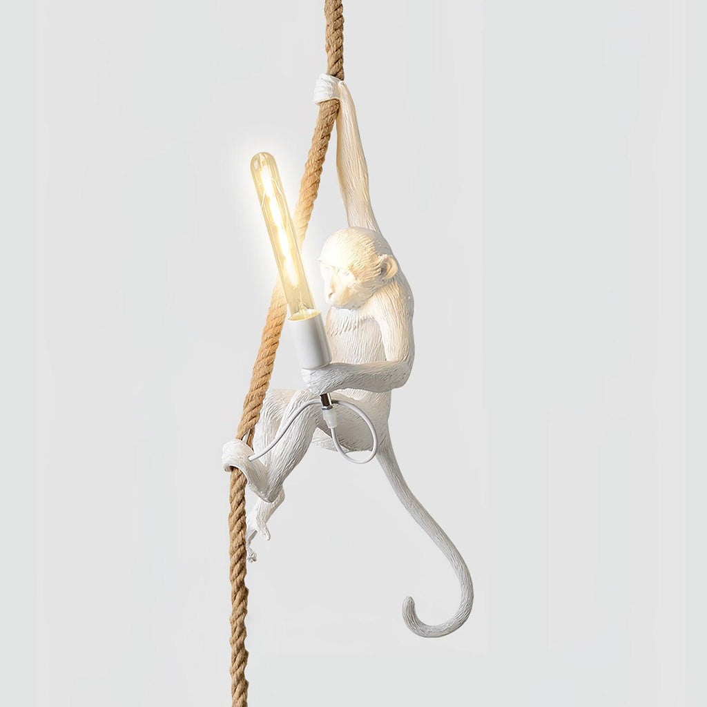 White monkey with one arm stretched up the rope and a long filament bulb lit in its hand, on a pale background; this Clérachic pendant.