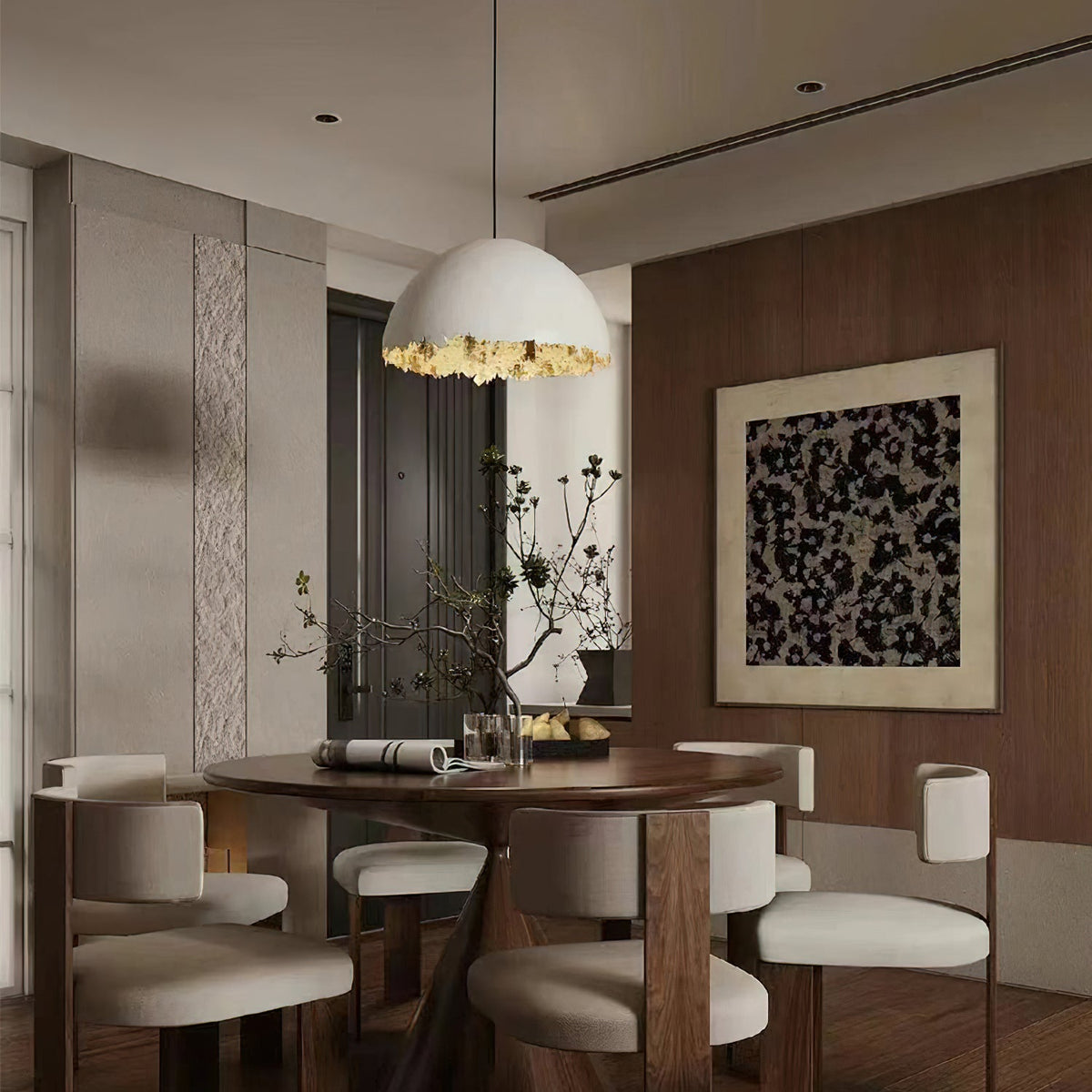 A Clérachic dome pendant with a gold rim hangs above a round dark wood table and cream chairs in a wood-panelled room.