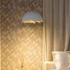 A Clérachic dome pendant with a gold edge hangs against a chevron wall, beside a long curtain and white pillows.