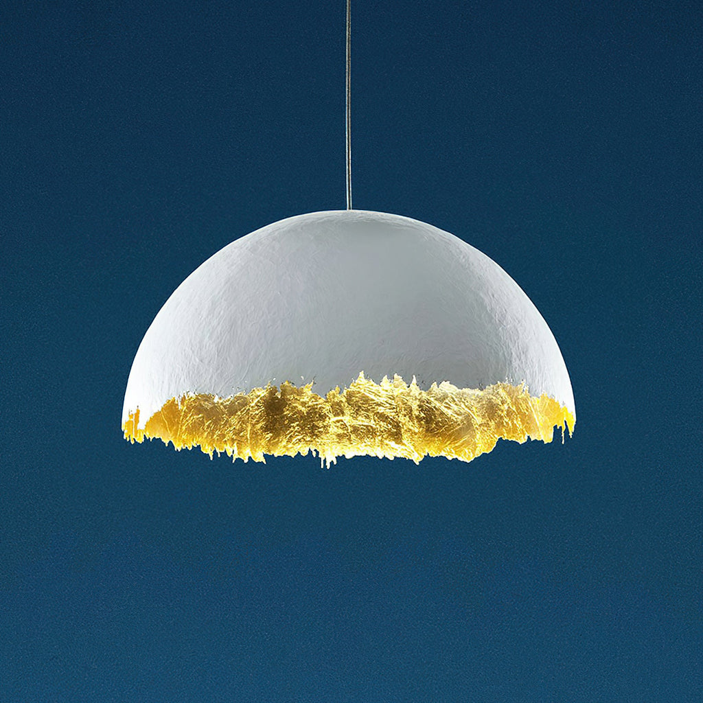 Clérachic dome pendant in white with a jagged gold-leaf lower edge, shown on a deep blue studio backdrop.