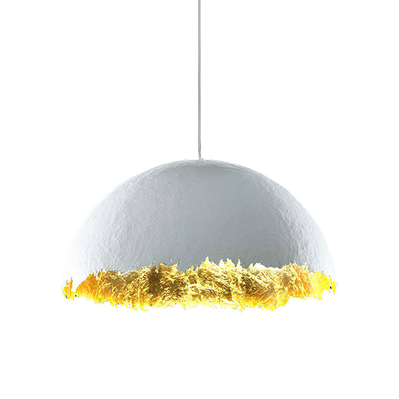 Wide Clérachic dome pendant with a matte white shell and gold-leaf lower edge, hung on a thin cord on white.