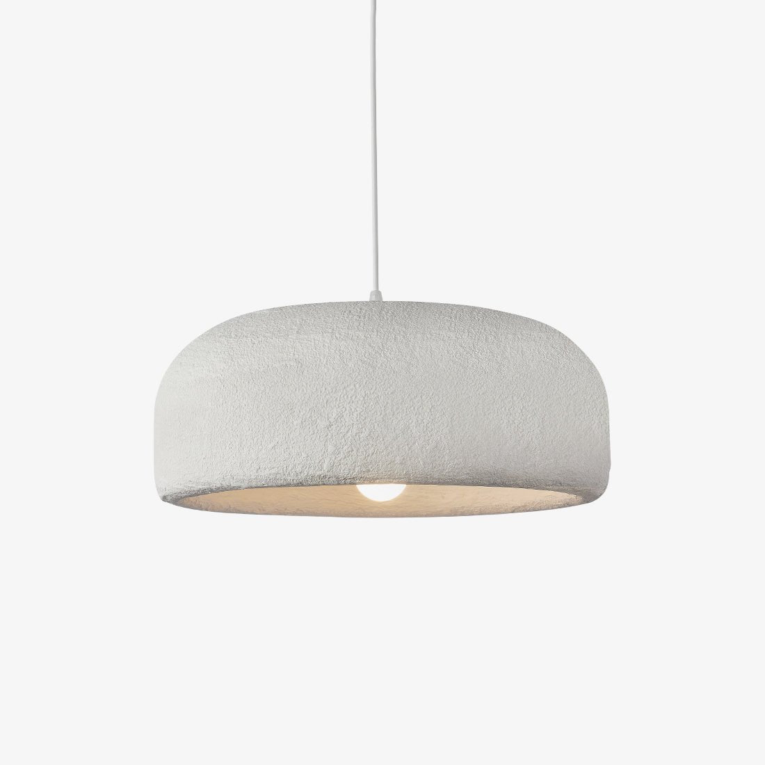This Clérachic pendant on a plain light backdrop, a wide white dome shade with a rough plaster-like texture and a bare bulb glowing below.