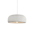 This Clérachic dome pendant on a plain white backdrop, with its white cord and a textured white shade over a bare bulb.
