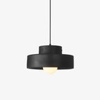 A black resin Clérachic pendant light with a stepped drum shade and a frosted globe bulb, on a plain white backdrop.