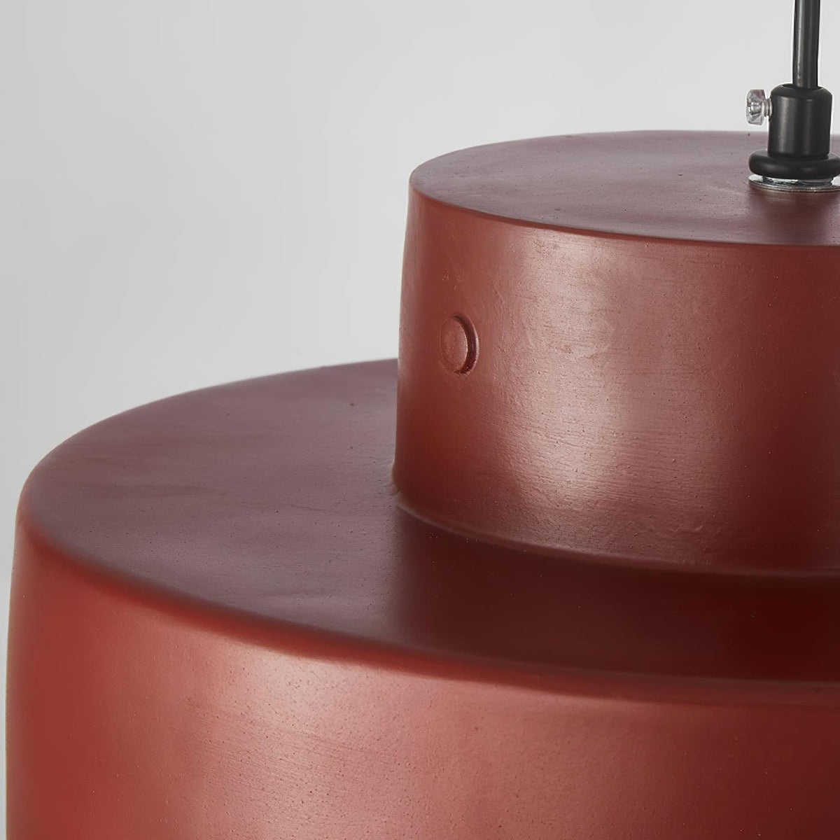 Close view of the stepped red resin shade on this Clérachic pendant, with a small screw detail and the black cord entering the top.