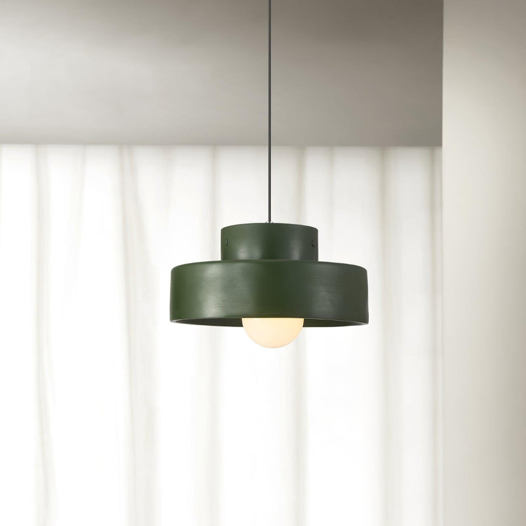 Green Clérachic pendant hanging in front of sheer white curtains, its frosted bulb glowing beneath the shade.