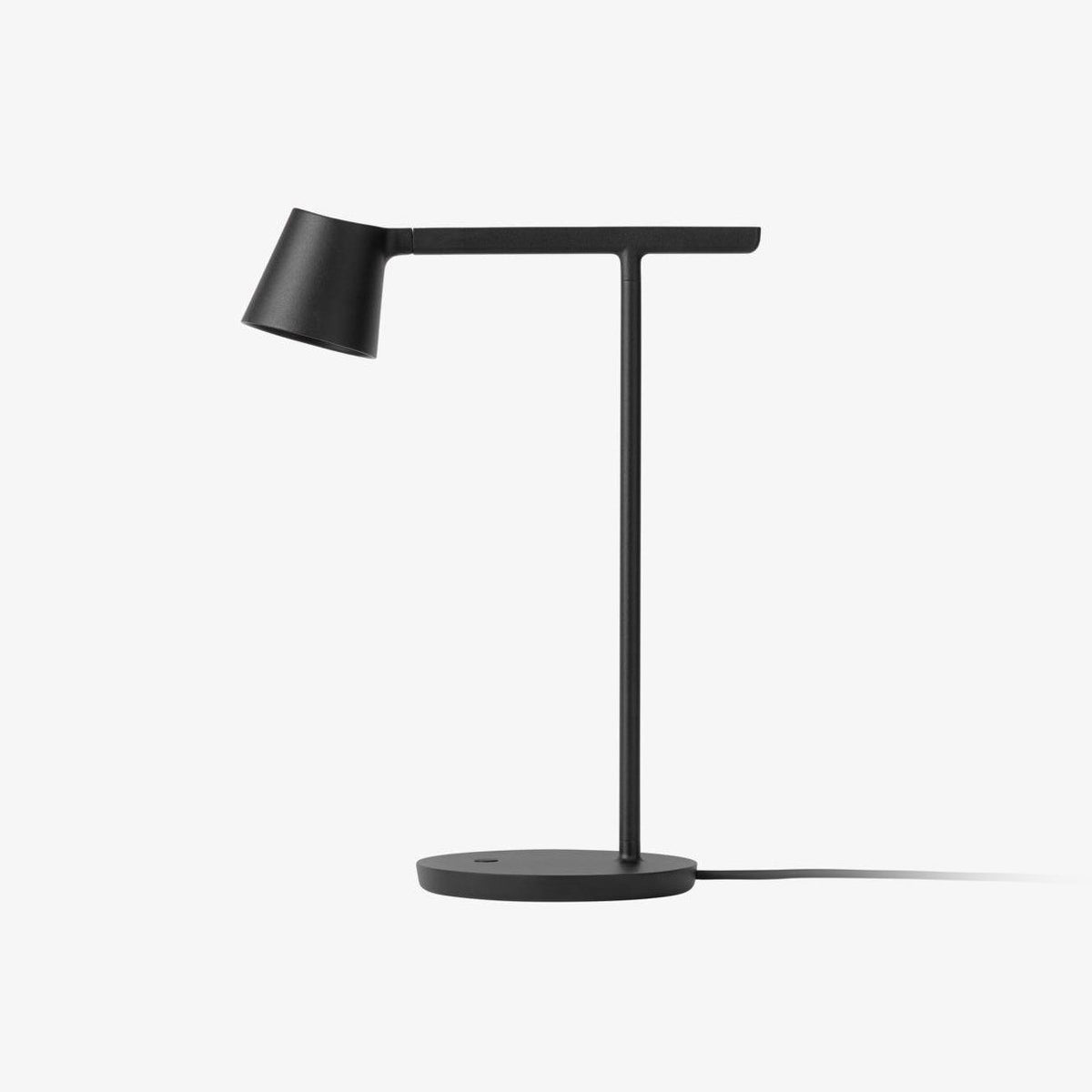 A black Clérachic table lamp on a plain white backdrop, with a slim T-shaped arm, angled head and round flat base.