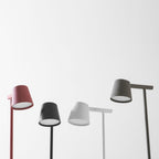 Close view of the lamp heads of four Clérachic table lamps in red, black, white and olive, lit from underneath.