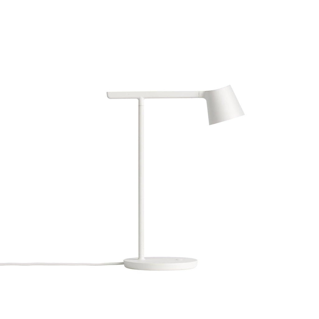 A white Clérachic table lamp against a white backdrop, with its angled head and white cord lying on the surface.