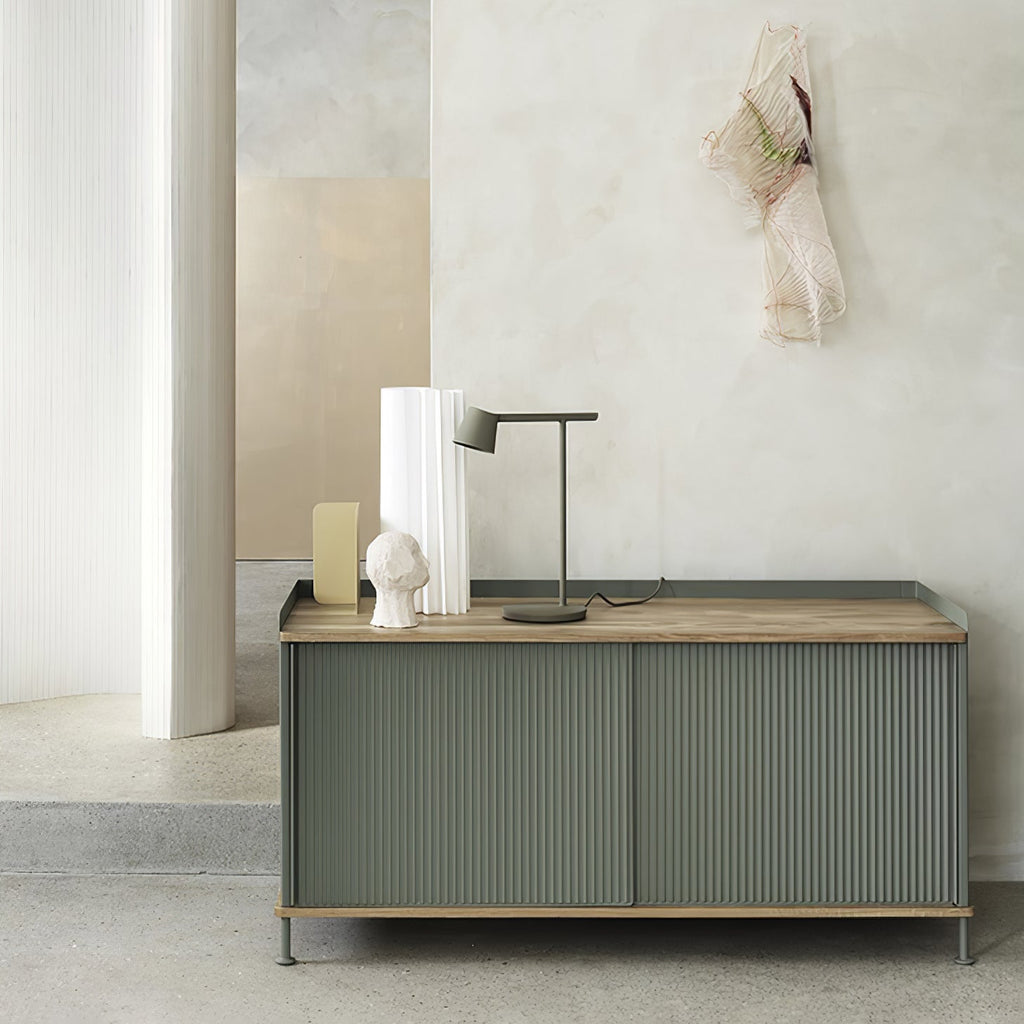 This Clérachic table lamp in olive on a sideboard with a wooden top, framed by a curved white wall.