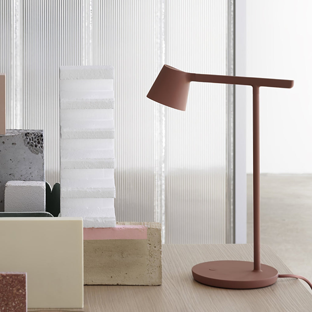 Rust-red Clérachic table lamp beside a tall white foam block and cream blocks, with a round disc base.