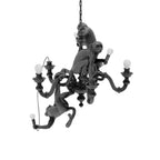 Black Clérachic chandelier with its monkeys and unlit bulbs, shown on a white backdrop from a slightly different angle.
