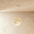 Clérachic moon pendant in a larger size, its crater-textured sphere glowing warm on a white cord from a round white canopy.