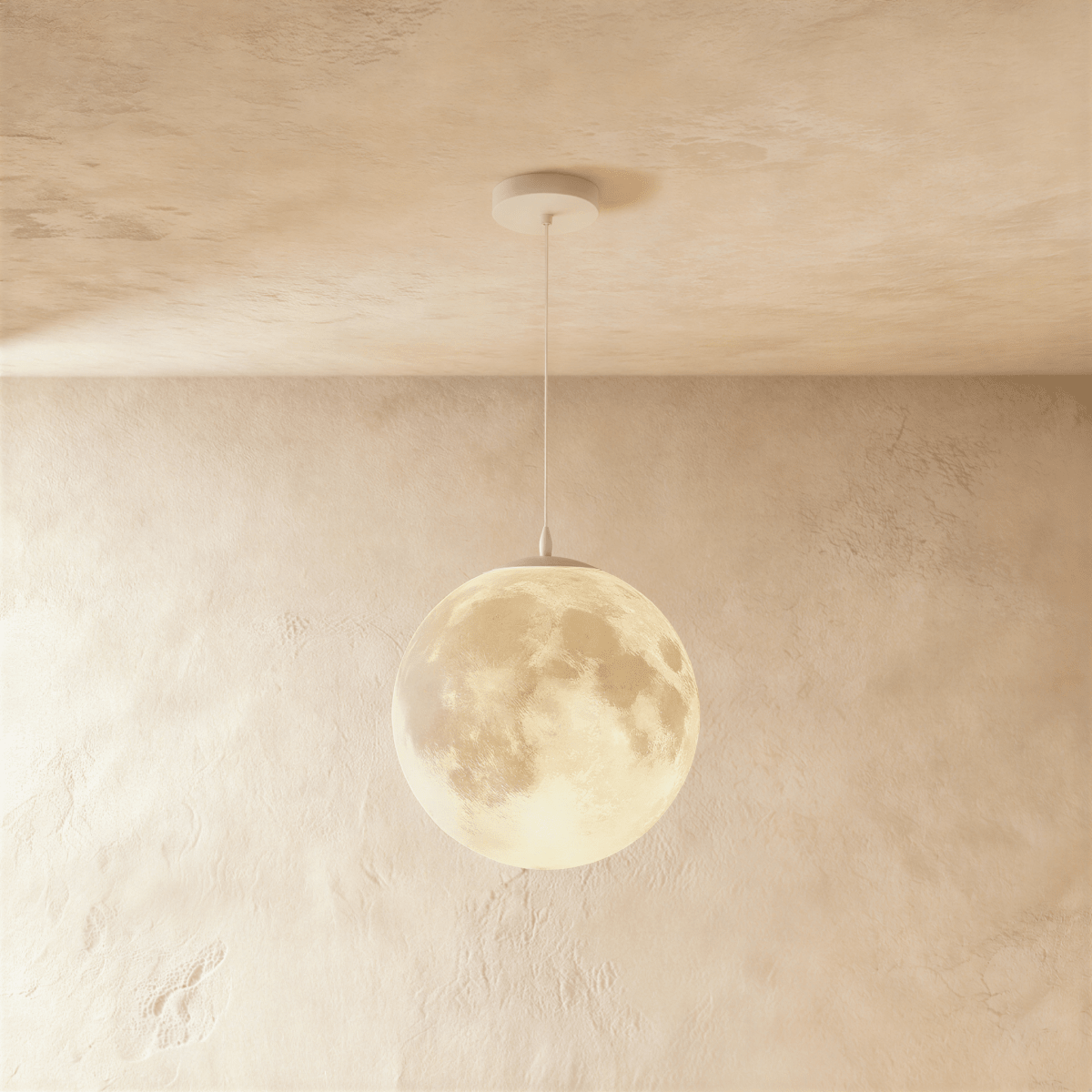 Clérachic moon pendant, the largest sphere of the set, glowing warm with crater detail on a white cord and canopy.