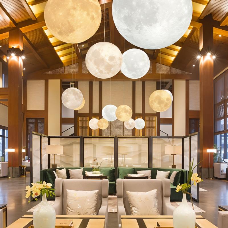 Clérachic cluster of moon pendants in many sizes and warm or cool light, hung through a tall timber-beamed lounge.