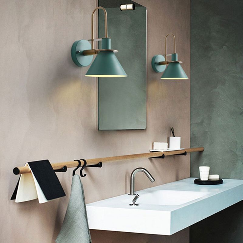 A pair of green Clérachic Morandi horn-shade wall sconces flanking a bathroom mirror above the vanity, where the IP44 rating lets them go.