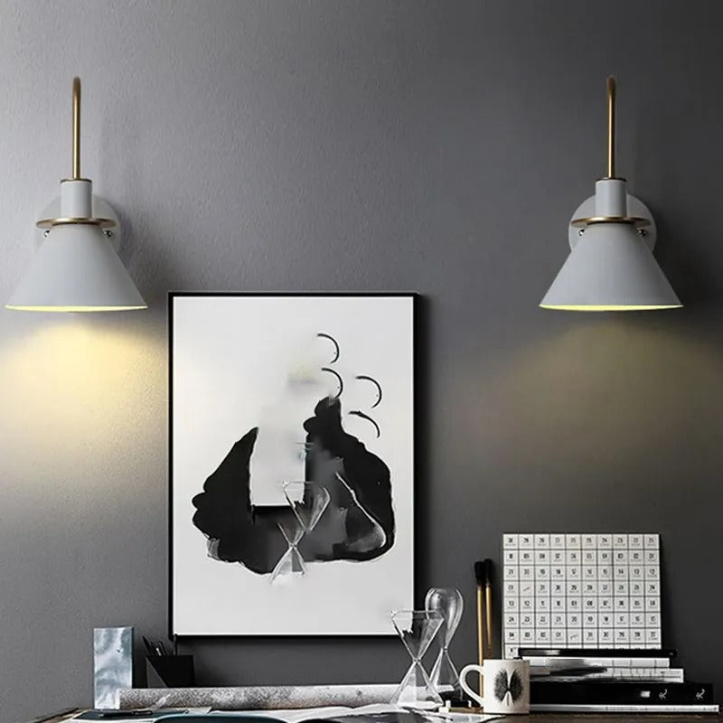 White Clérachic Morandi horn-shade wall sconces either side of a framed ink print above a desk, each washing the dark grey wall below.