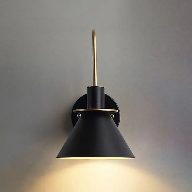 Head-on view of the black Clérachic Morandi horn-shade wall sconce lit on a grey wall, the cream interior throwing light straight down.