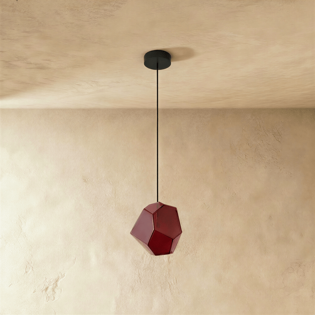 Side view of the Clérachic rose red glass pendant shows its angular cut facets catching light on plaster walls.