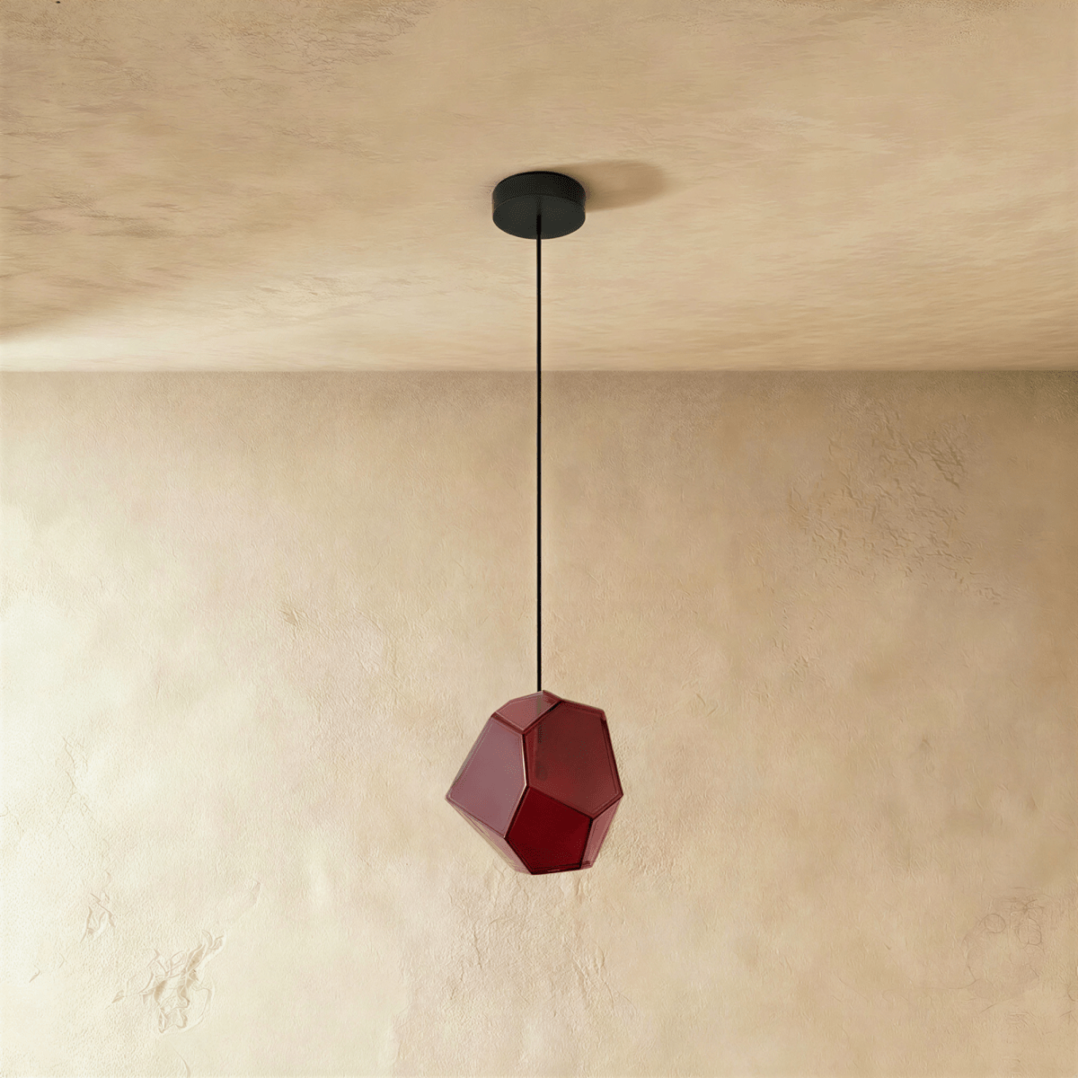 Side view of the Clérachic rose red glass pendant shows its angular cut facets catching light on plaster walls.