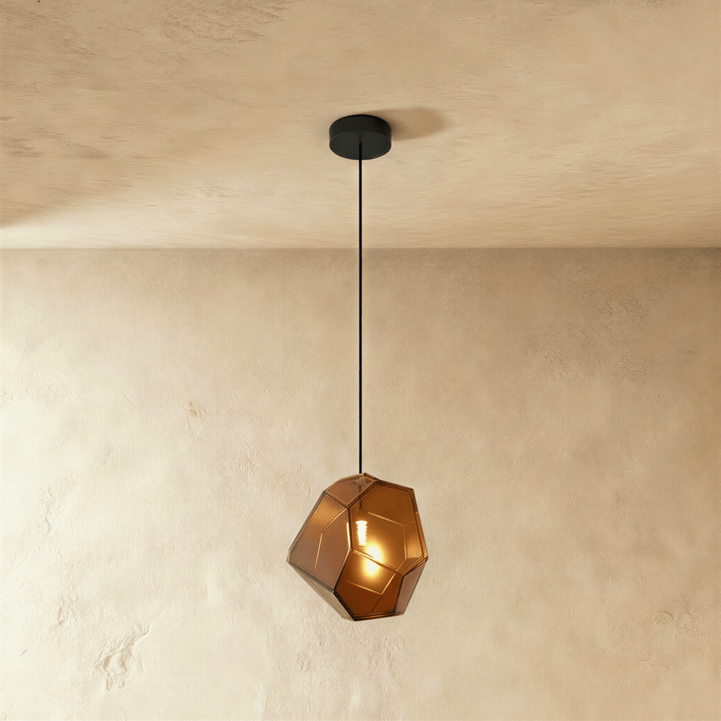 This Clérachic pendant's amber-brown faceted glass glows warmly, the bulb visible through its angled panes.