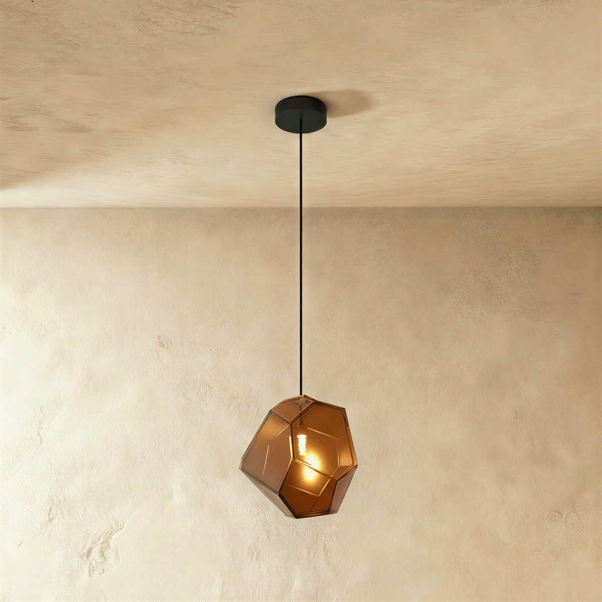 This Clérachic pendant's amber-brown faceted glass glows warmly, the bulb visible through its angled panes.
