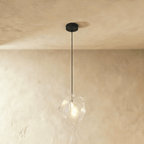 This Clérachic pendant's clear faceted glass shows its exposed bulb plainly through the angled cut panes.
