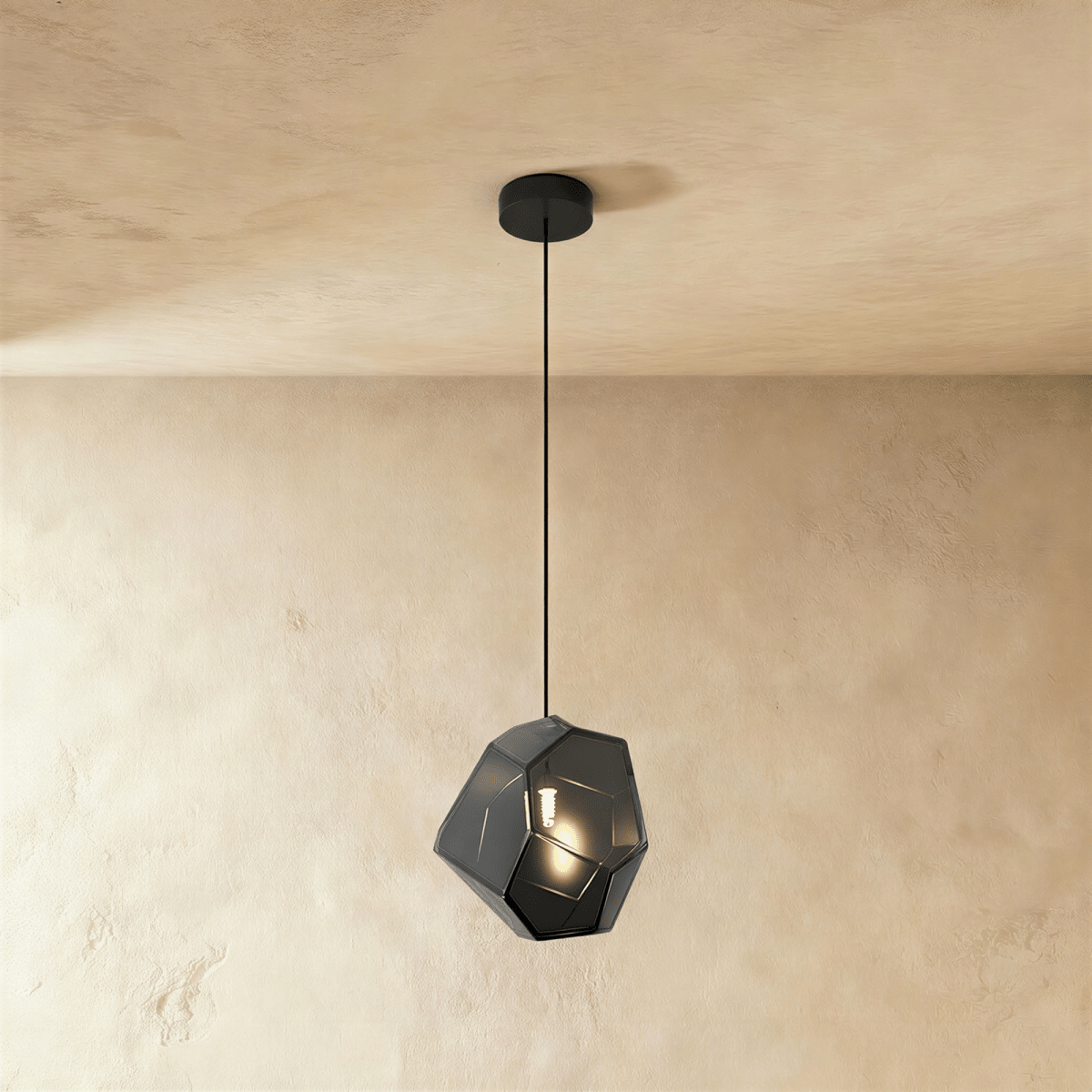 This Clérachic pendant's light gray faceted glass glows softly, the bulb visible through its angled panes.