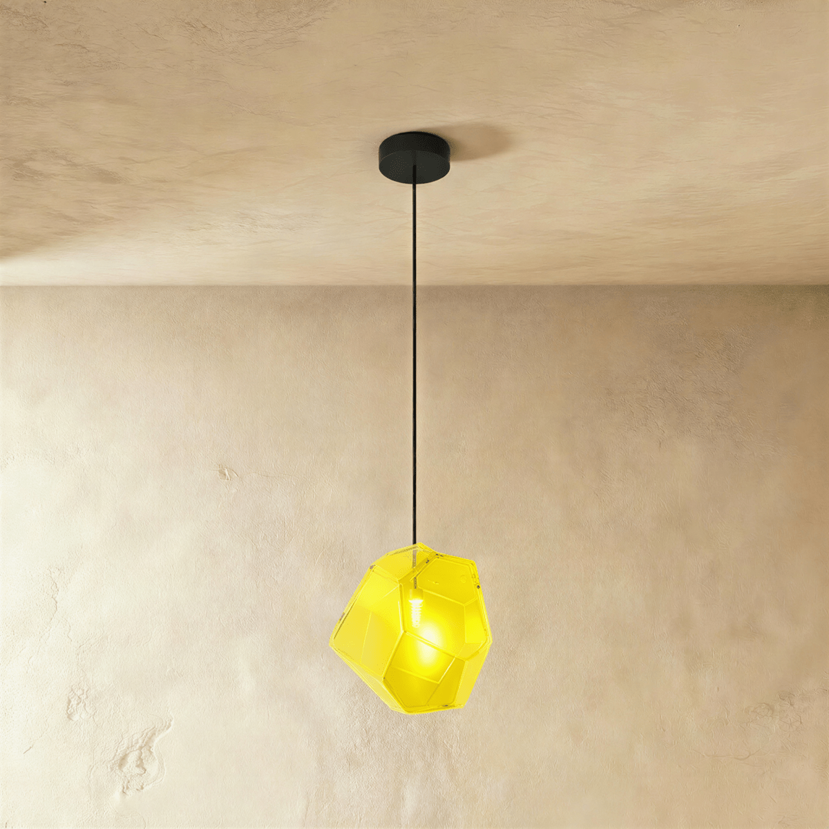 This Clérachic pendant's yellow faceted glass glows brightly, the bulb visible through its angled cut panes.