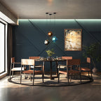 Three Clérachic faceted glass pendants in gray, brown and blue cluster above a round table against a dark teal wall.