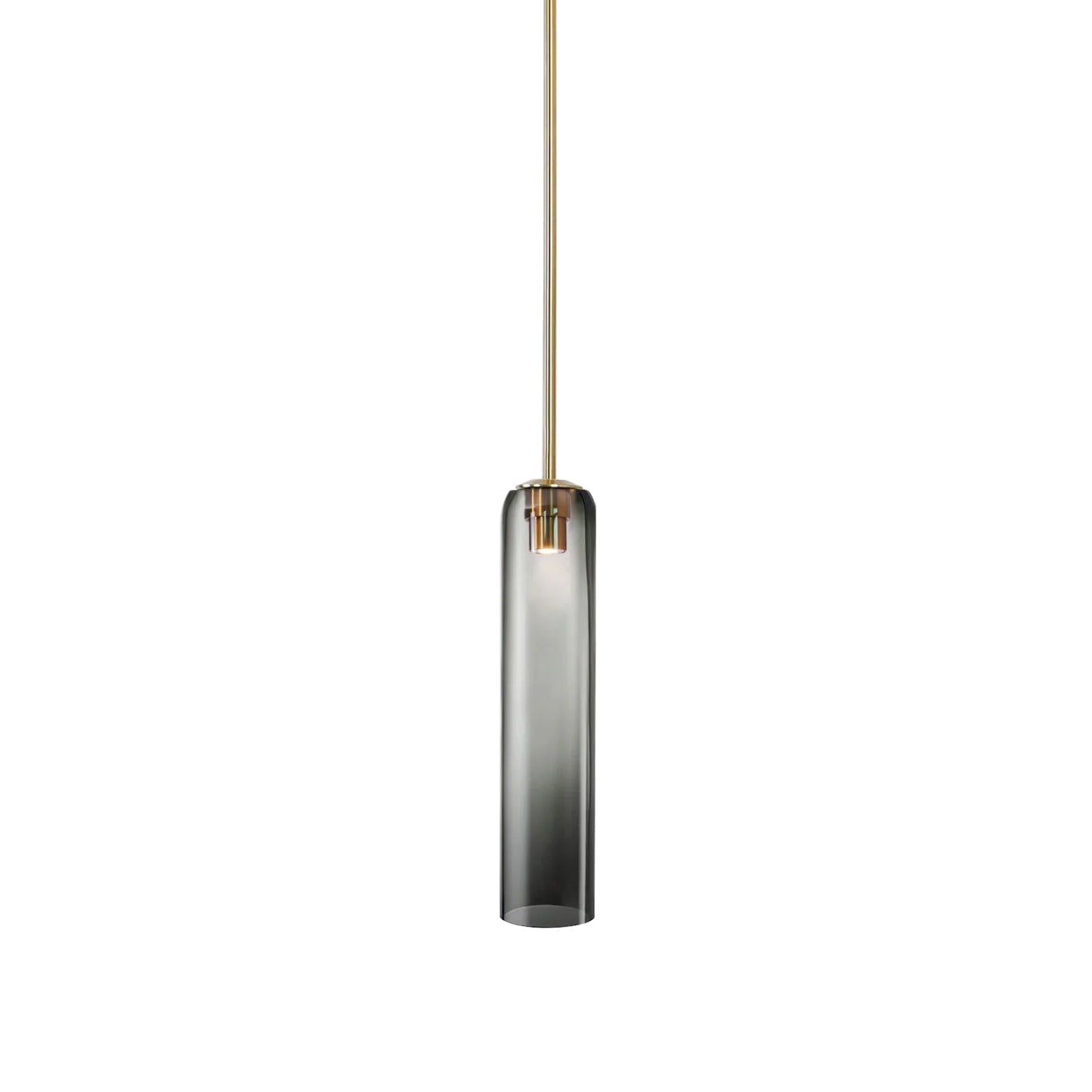 Smoke grey glass on the Clérachic tube pendant, lit on a brass rod, darkest at the top and fading toward the base.
