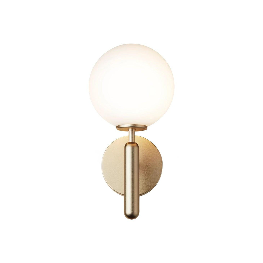 Shown from a slightly different angle, this brass Clérachic wall light's white glass globe stands against a plain white background.