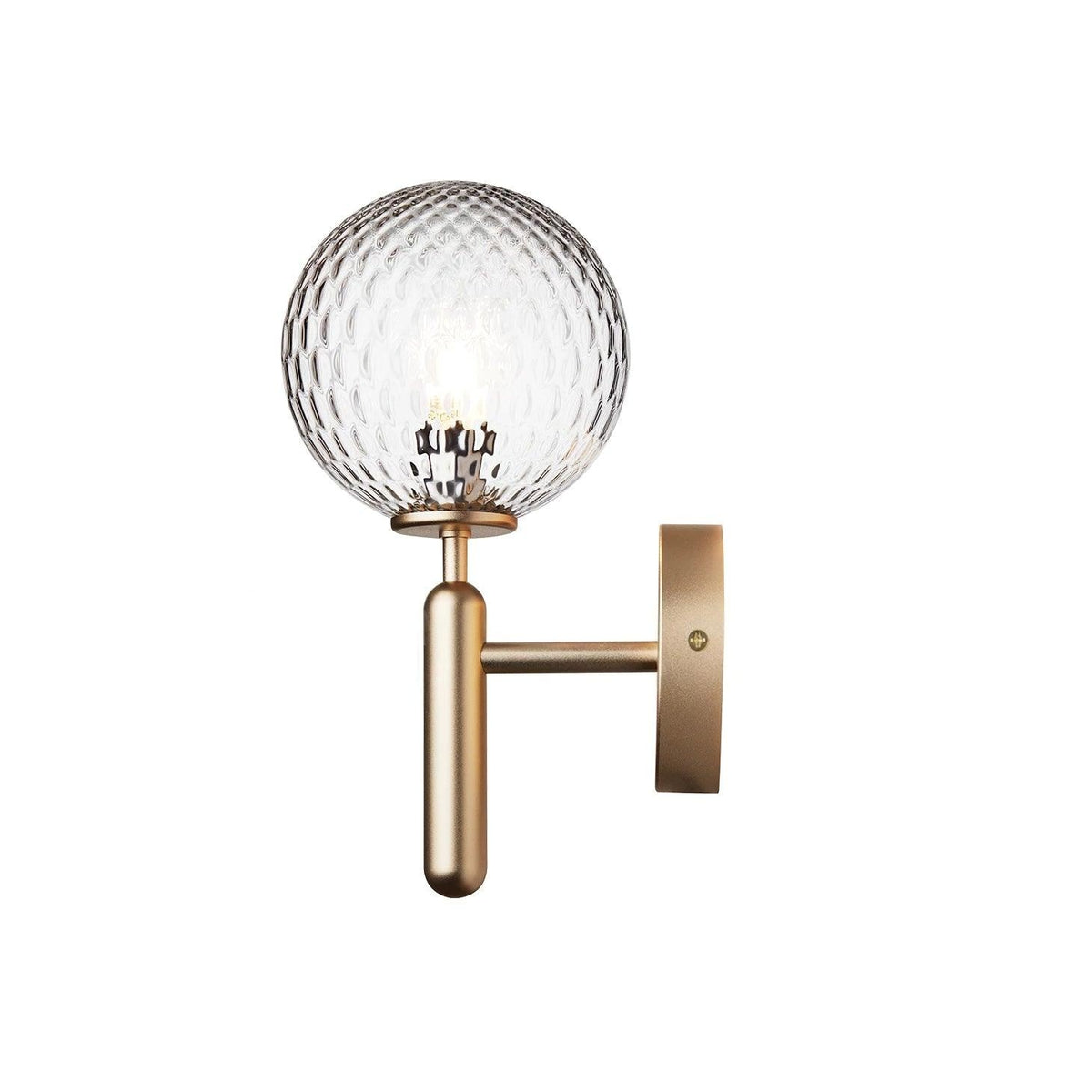 Lit, this brass Clérachic wall light's dimpled clear glass globe stands against a plain white background.