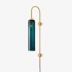 Clérachic mouth-blown glass wall sconce in deep teal on a gold body, hung from its arched gooseneck above two disc mounts.