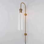 The Clérachic mouth-blown glass wall sconce in clear glass on gold, the bulb and its sleeve left on show inside the cylinder.