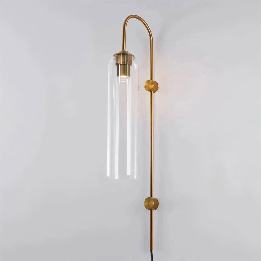 The Clérachic mouth-blown glass wall sconce in clear glass on gold, the bulb and its sleeve left on show inside the cylinder.