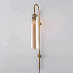 Amber glass on the Clérachic mouth-blown wall sconce, the lit cylinder warming to honey against a pale grey wall.